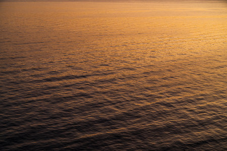 Water sea sunset. Sun reflection ocean waves. Nature golden abstract texture surface.の写真素材