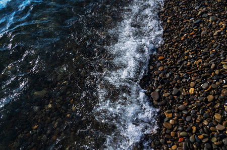 Water sea beach. Wave ocean blue. Stone texture reflection sun. Surface coast pebbles. Abstract light rock background.の写真素材