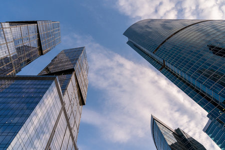 Angled view of modern skyscrapers in business district against blue sky. Looking Up high-rise office buildings.の写真素材