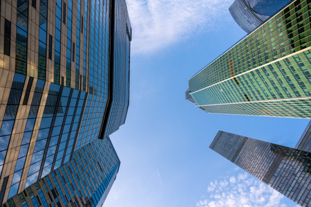 Angled view of modern skyscrapers in business district against blue sky. Looking Up high-rise office buildings.の写真素材