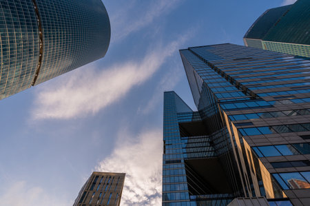 Angled view of modern skyscrapers in business district against blue sky. Looking Up high-rise office buildings.の写真素材