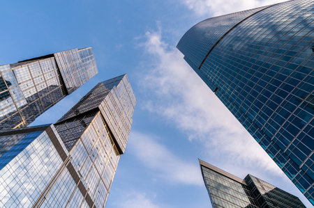 Angled view of modern skyscrapers in business district against blue sky. Looking Up high-rise office buildings.の写真素材