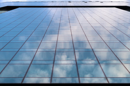 Angled view of modern skyscrapers in business district against blue sky. Looking Up high-rise office...