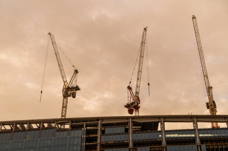 Construction cranes against dramatic sky. High rise building construction. Sunset or sunrise.の写真素材