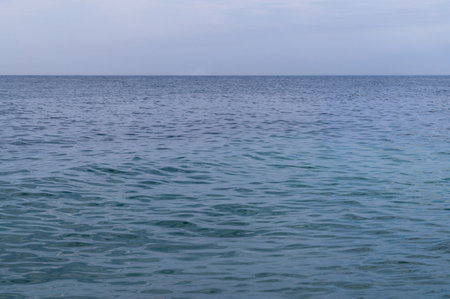 Blue sea surface with to the horizon. Sea waves with cloudy sky. Abstract background of water flow in ocean, sea, river, lake. Seascape wallpaper.の写真素材