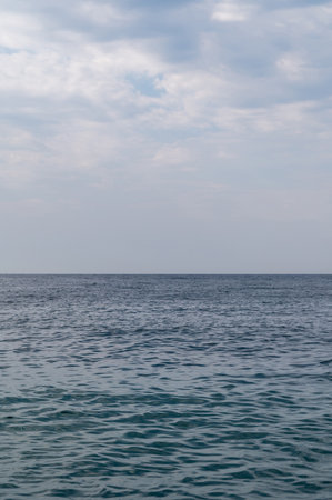 Blue sea surface with to the horizon. Sea waves with cloudy sky. Abstract background of water flow in ocean, sea, river, lake. Seascape wallpaper.の写真素材
