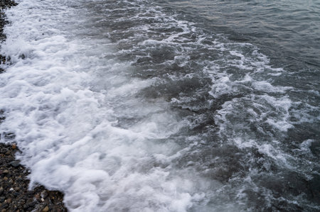 Sea beach. Wave ocean blue. Water splash texture. Surface coast pebbles.の写真素材