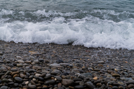 Sea beach. Wave ocean blue. Water splash texture. Surface coast pebbles.の写真素材