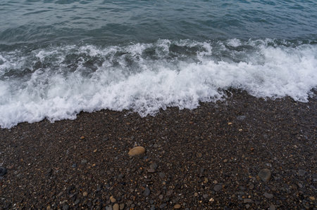 Sea beach. Wave ocean blue. Water splash texture. Surface coast pebbles.の写真素材