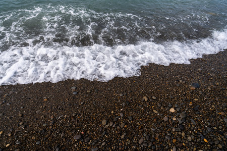 Sea beach. Wave ocean blue. Water splash texture. Surface coast pebbles.の写真素材