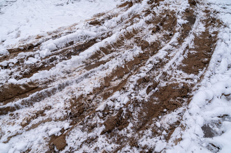 Tire tracks in the ice mud of winter in rural with snow. Off-road in frozen land. Landscape nature background.の写真素材