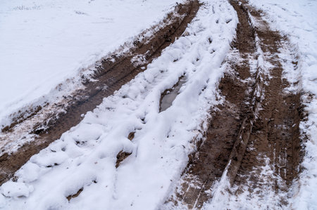 Tire tracks in the ice mud of winter in rural with snow. Off-road in frozen land. Landscape nature background.の写真素材