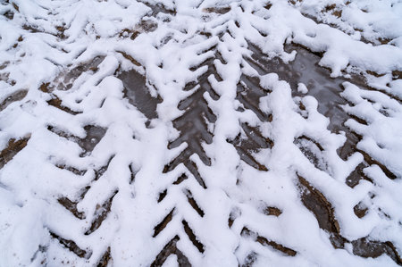 Tire tracks in the ice mud of winter in rural with snow. Off-road in frozen land. Landscape nature background.の写真素材