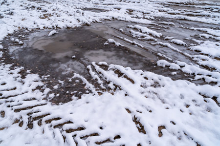 Tire tracks in the ice mud of winter in rural with snow. Off-road in frozen land. Landscape nature background.の写真素材