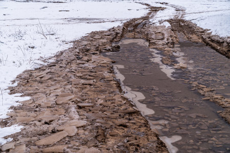 Tire tracks in the ice mud of winter in rural with snow. Off-road in frozen land. Landscape nature background.の写真素材