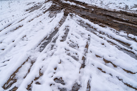 Tire tracks in the ice mud of winter in rural with snow. Off-road in frozen land. Landscape nature background.の写真素材
