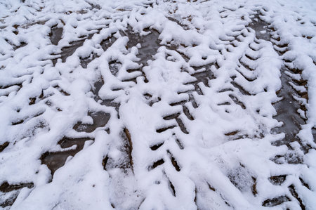 Tire tracks in the ice mud of winter in rural with snow. Off-road in frozen land. Landscape nature background.の写真素材