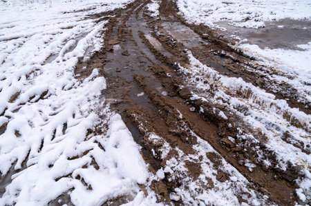 Tire tracks in the ice mud of winter in rural with snow. Off-road in frozen land. Landscape nature background.の写真素材