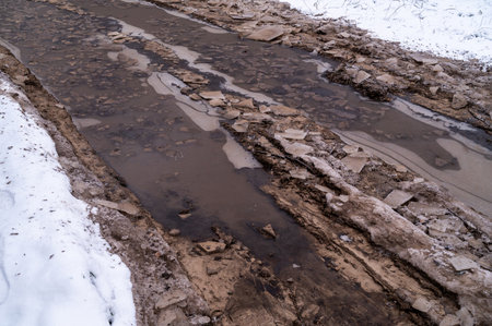 Tire tracks in the ice mud of winter in rural with snow. Off-road in frozen land. Landscape nature background.の写真素材
