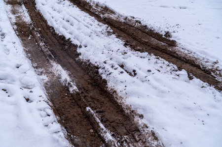 Tire tracks in the ice mud of winter in rural with snow. Off-road in frozen land. Landscape nature background.の写真素材