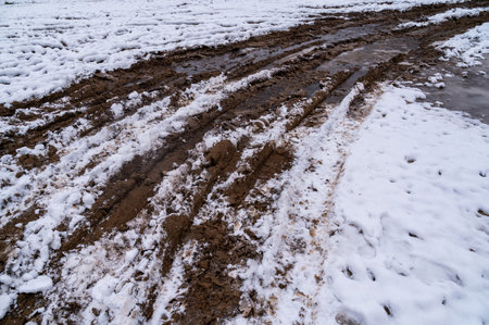 Tire tracks in the ice mud of winter in rural with snow. Off-road in frozen land. Landscape nature background.の写真素材