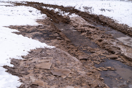 Tire tracks in the ice mud of winter in rural with snow. Off-road in frozen land. Landscape nature background.の写真素材