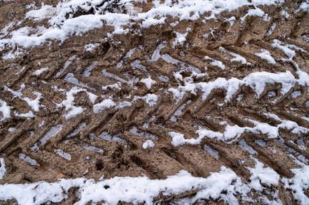 Tire tracks in the ice mud of winter in rural with snow. Off-road in frozen land. Landscape nature background.の写真素材