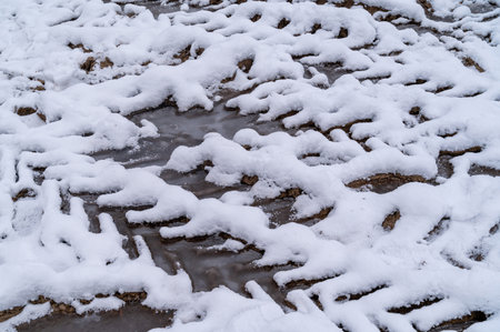 Tire tracks in the ice mud of winter in rural with snow. Off-road in frozen land. Landscape nature background.の写真素材