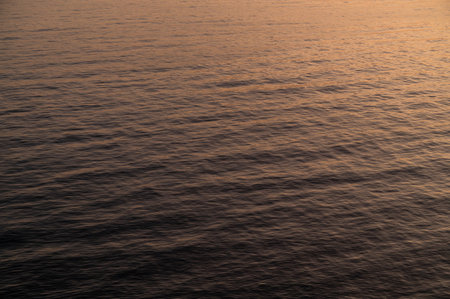 Water sea sunset. Sun reflection ocean waves. Nature golden abstract texture surface.の写真素材