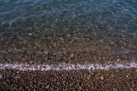 Sea beach. Wave ocean blue. Water splash texture. Surface coast pebbles.の写真素材