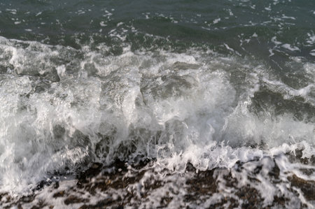 Sea beach. Wave ocean blue. Water splash texture. Surface coast pebbles.の写真素材