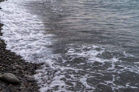 Sea beach. Wave ocean blue. Water splash texture. Surface coast pebbles.の写真素材