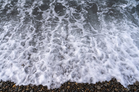 Sea beach. Wave ocean blue. Water splash texture. Surface coast pebbles.の写真素材