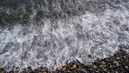 Sea beach. Wave ocean blue. Water splash texture. Surface coast pebbles.の写真素材