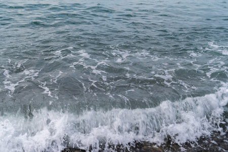 Sea beach. Wave ocean blue. Water splash texture. Surface coast pebbles.の写真素材