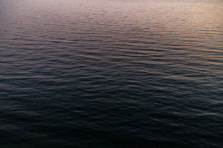 Water sea sunset. Sun reflection ocean waves. Nature golden abstract texture surface.の写真素材