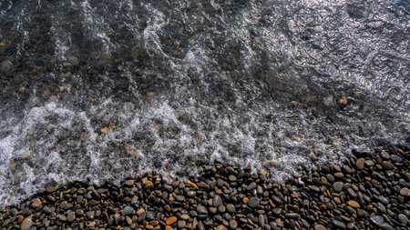 Sea beach. Wave ocean blue. Water splash texture. Surface coast pebbles.の写真素材