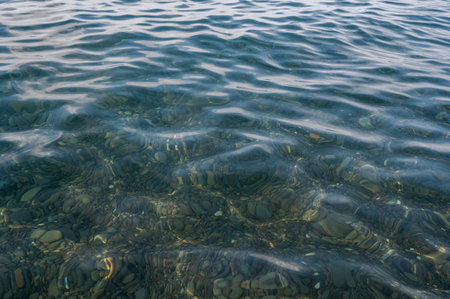Underwater pebble backgrounds. Colorful stones sea bottom in the sun rays. View from above through clear water. Seascape wallpaper texture. Soft focus.の写真素材