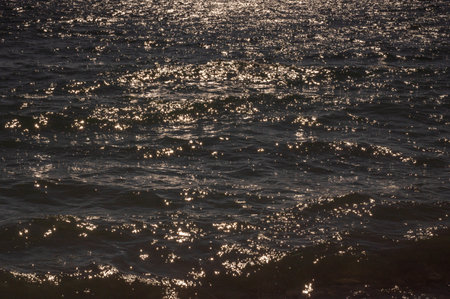 Sparkling sea water. Sun starburst over the sea on sunny day. Marine surface glitter texture. Sparkle sea wave closeup. Abstract sunburst background.の写真素材