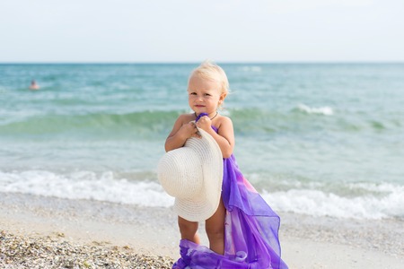 The child, a little girl posing on the beach, small model on the beach, summer vacation at seaの写真素材