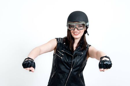 Fashion portrait of sexy stunning hipster woman, bright make up, vintage sunglasses, biker leather jacket, trendy jewelry and accessorizes. Urban wall background. Photoshoot relaxed bikerの写真素材