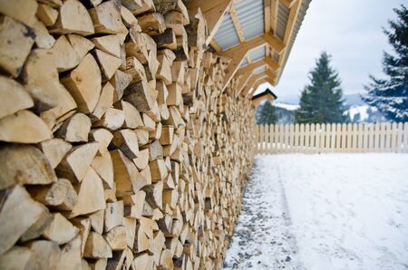 The wall of neatly stacked wood, harvested in winter.