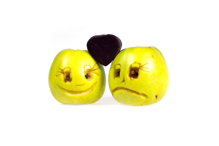Happy and sad emoticons apples keep candy in the shape of a heart. Feelings, attitudes and emotions.の写真素材