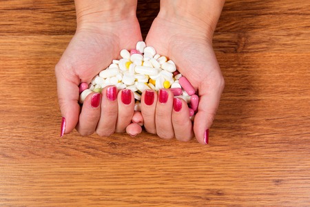 Treatment of diseases with modern methods. Homeopathic and chemicals. Various kinds of drugs in female hands.の写真素材