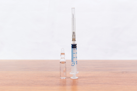 Medical syringe and drugs on a table close-up. Drug addiction.の写真素材