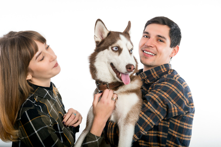 Family: husband, wife and pet pet dog of the Husk breed posing on the camera.の写真素材