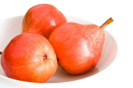 Three Red Pears on a white Plateの写真素材