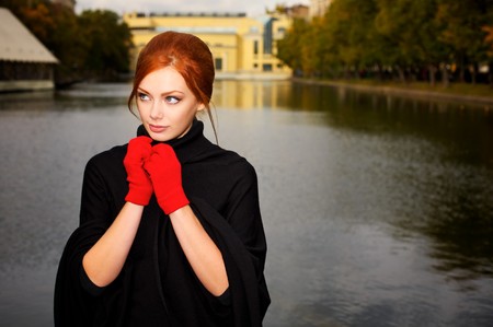 Portrait of a beautiful red-haired woman in red glovesの写真素材