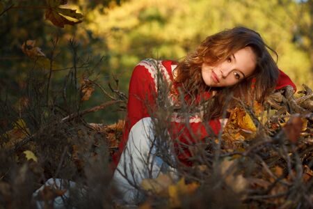 Beautiful young woman in autumn parkの写真素材
