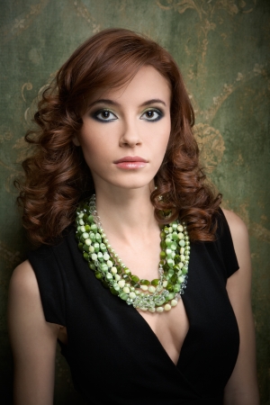 Portrait of pretty young woman with green beadsの写真素材